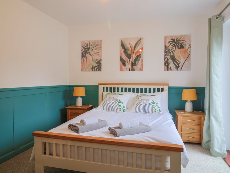 A bedroom with a bed and nightstands at 2 North Road, Maiden Newton, Dorset