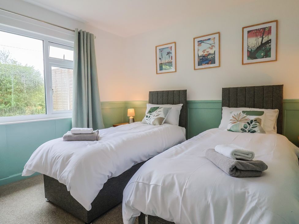 A bedroom with twin beds and artwork on the wall at 2 North Road, Maiden Newton, Dorset