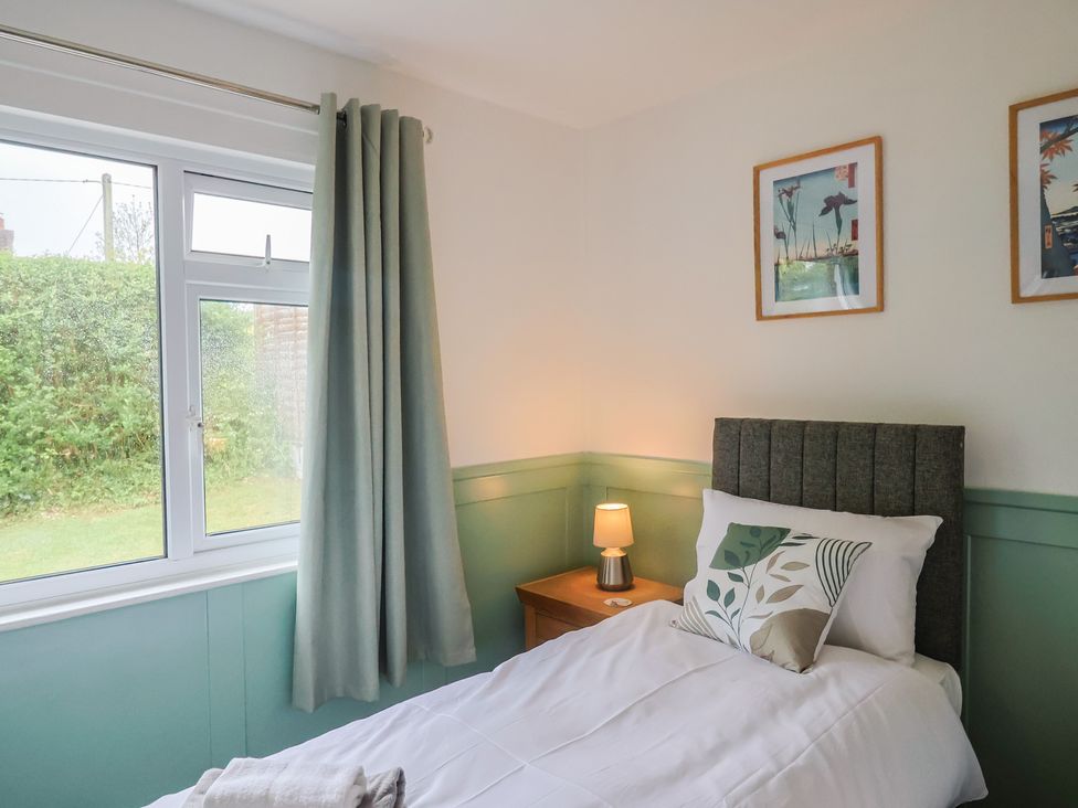 A bedroom with a bed and window at 2 North Road, Maiden Newton, Dorset
