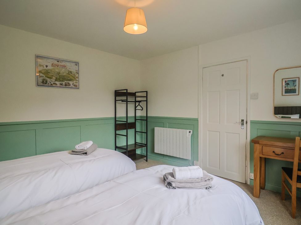 A bedroom with two beds and a shelf at 2 North Road in Maiden Newton, Dorset
