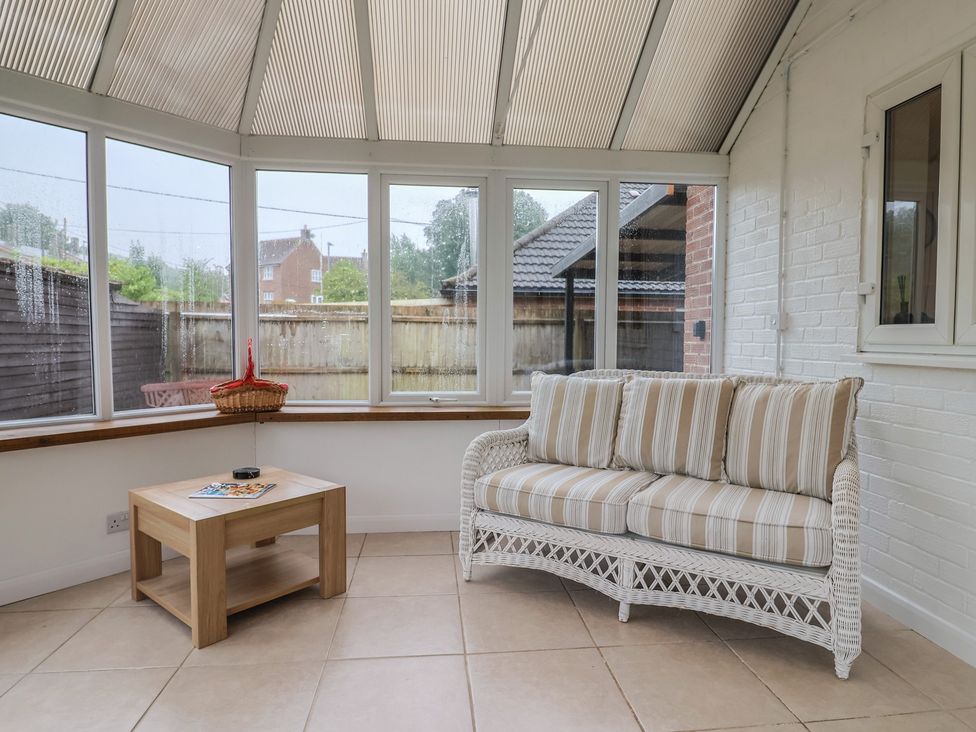 A conservatory with a sofa and a table at 2 North Road, Maiden Newton, Dorset