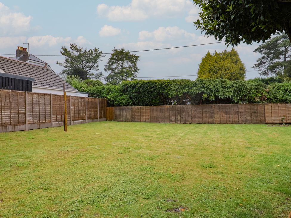 A garden with grass and fences at 2 North Road in Maiden Newton, Dorset