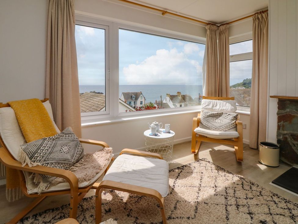 A living room with chairs and a view of the sea at Wootton Gray in Penzance