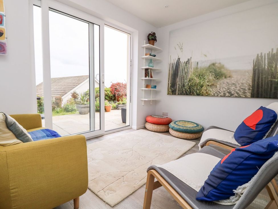 A snug with sliding doors and decorative cushions at Wootton Gray in Penzance