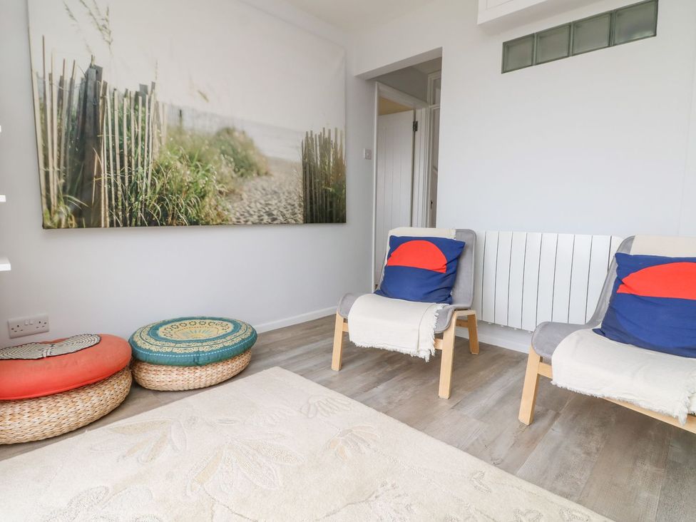 A living room with seating and wall art at Wootton Gray in Penzance