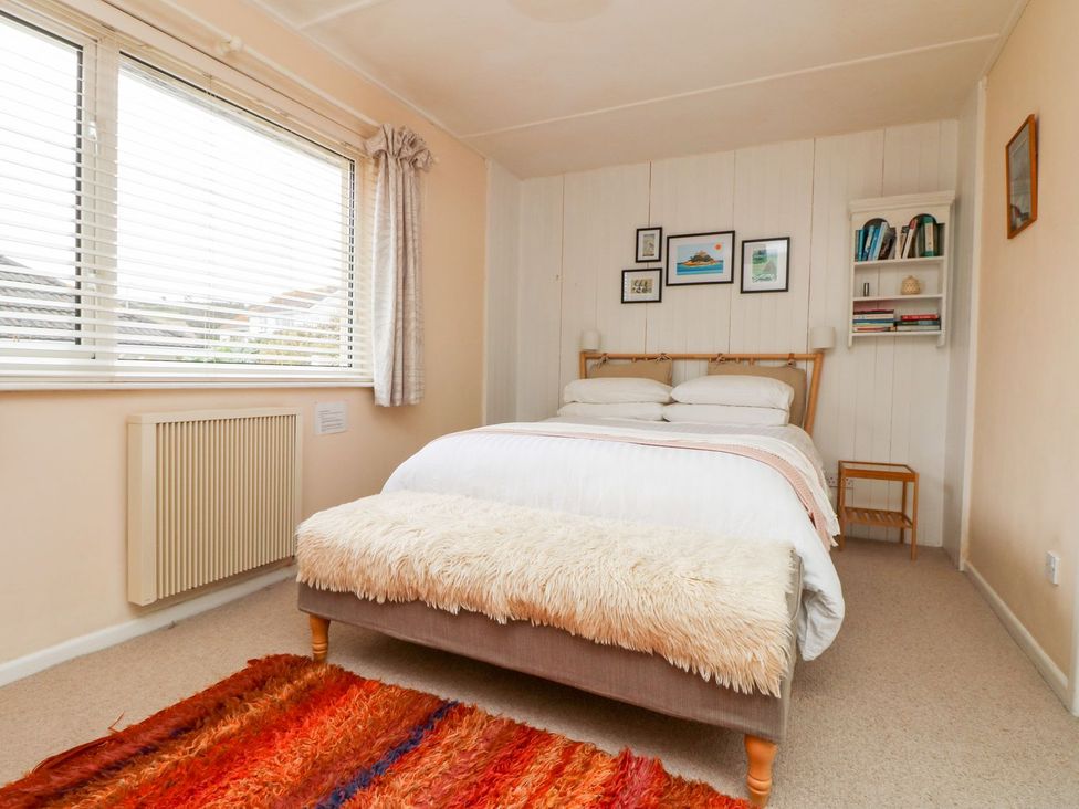 A bedroom with a bed and bookshelf at Wootton Gray in Penzance