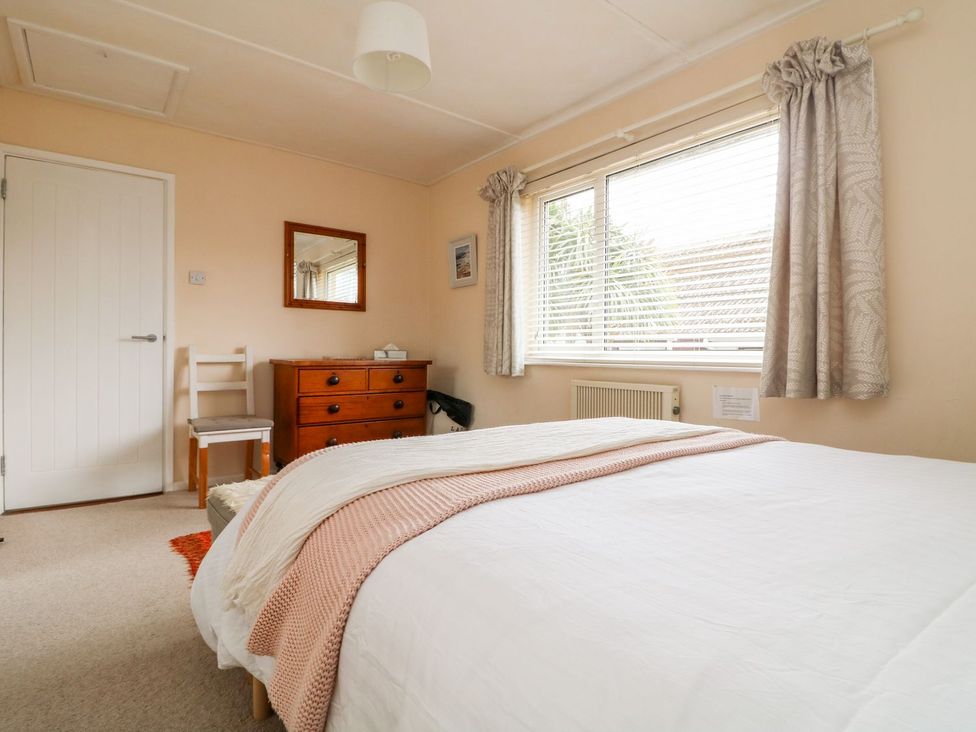 A bedroom with a bed and dresser at Wootton Gray in Penzance