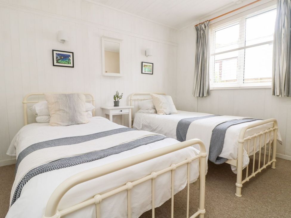 A bedroom with two beds and a nightstand at Wootton Gray in Penzance
