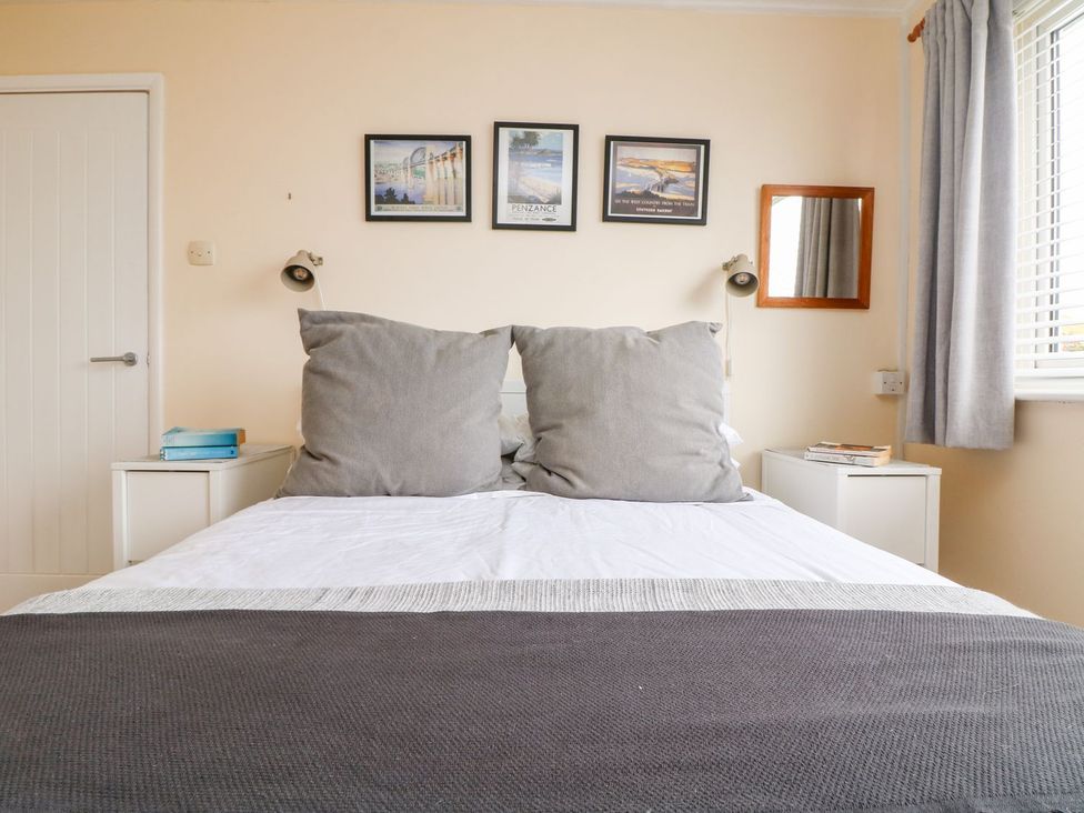 A bedroom with a bed and bedside tables at Wootton Gray in Penzance