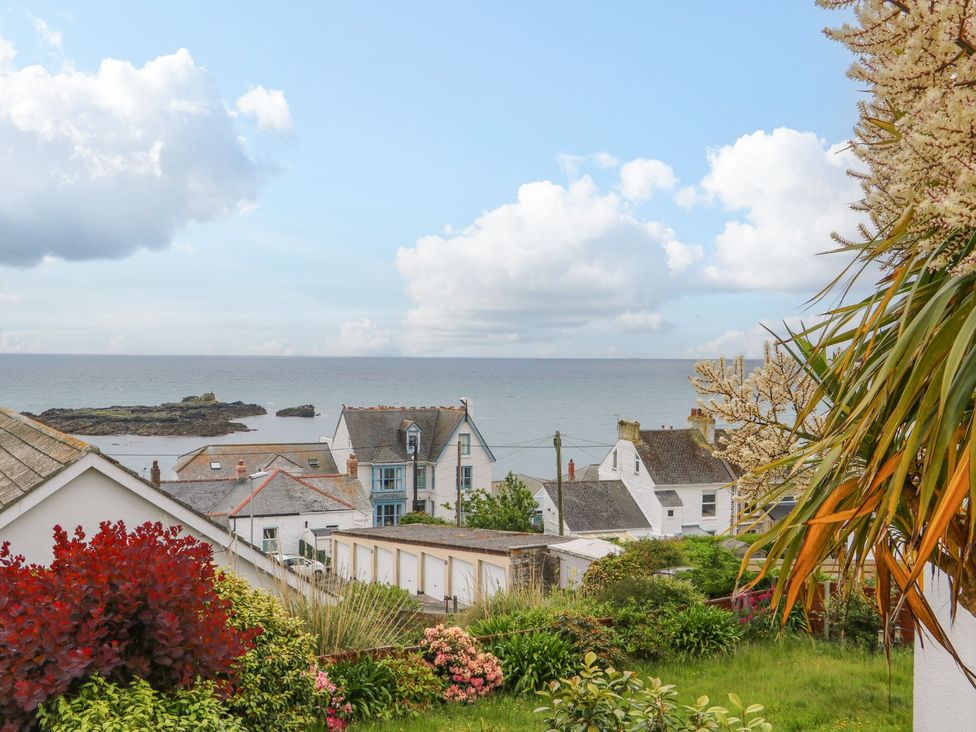 A view of the sea and houses with flowers at Wootton Gray in Penzance