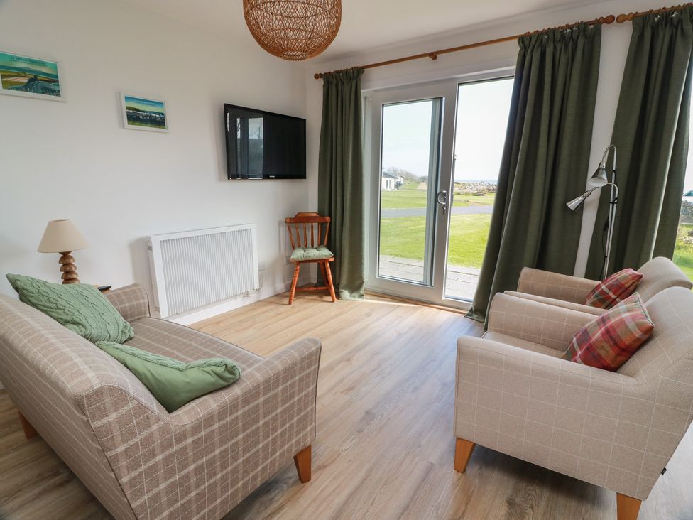 A living room with a sofa and armchairs at 15 Laigh Isle 
