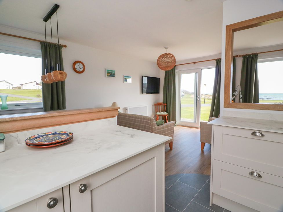 A kitchen and living area with seating and a window at 15 Laigh Isle