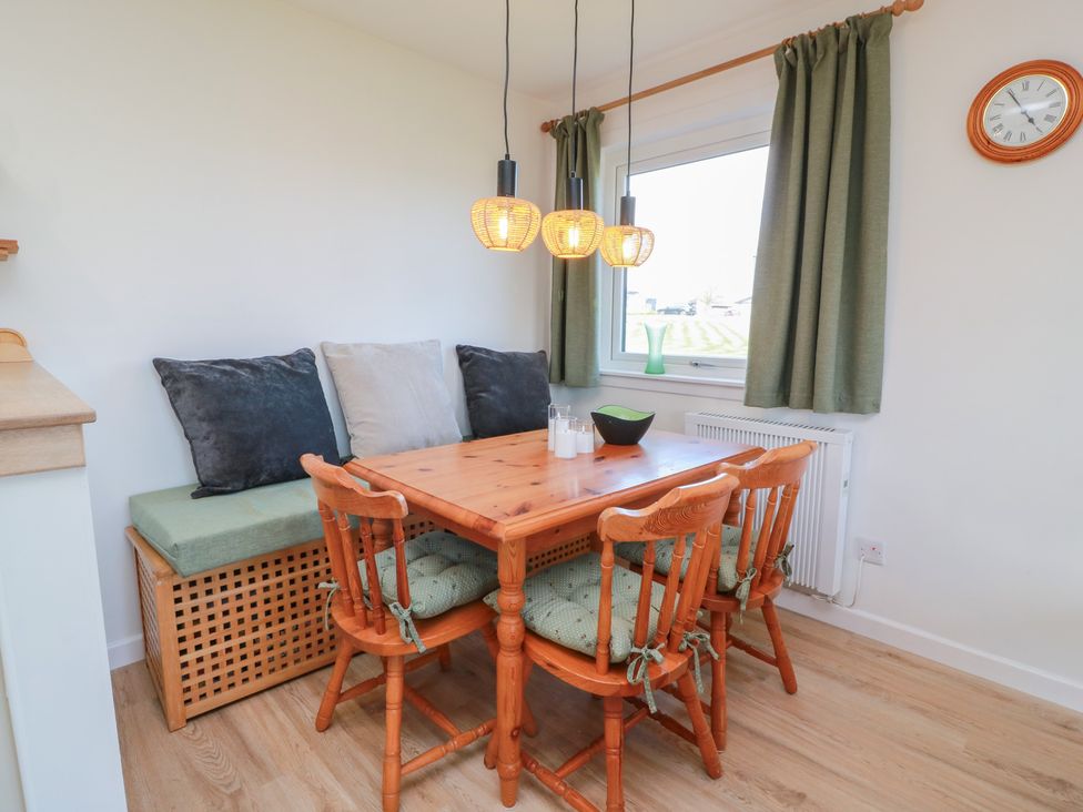 A dining room with a table and chairs at 15 Laigh Isle