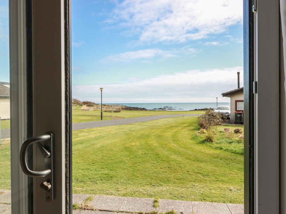 View from a window showing grass and sea at 15 Laigh Isle