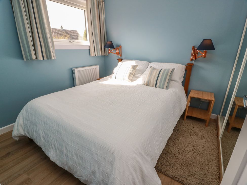 A bedroom with a bed and bedside table at 15 Laigh Isle