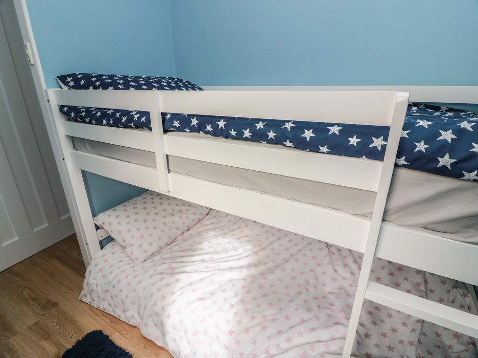 A bunk bed with star-patterned mattresses in a bedroom at 15 Laigh Isle