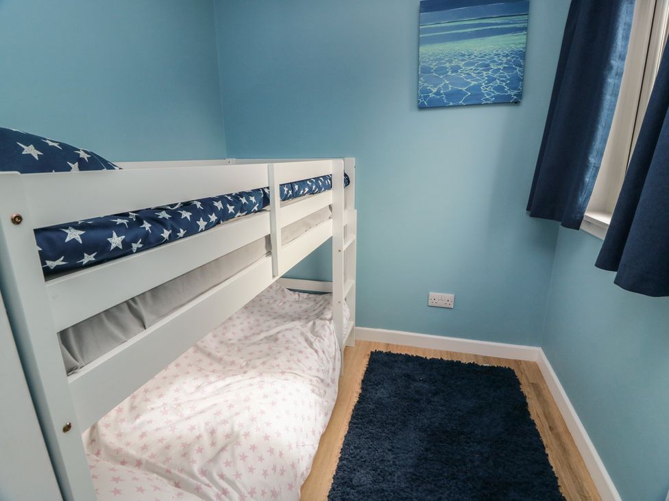A bedroom with a bunk bed and rug at 15 Laigh Isle