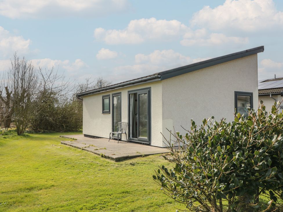 A house with a patio and chair in a garden at 15 Laigh Isle