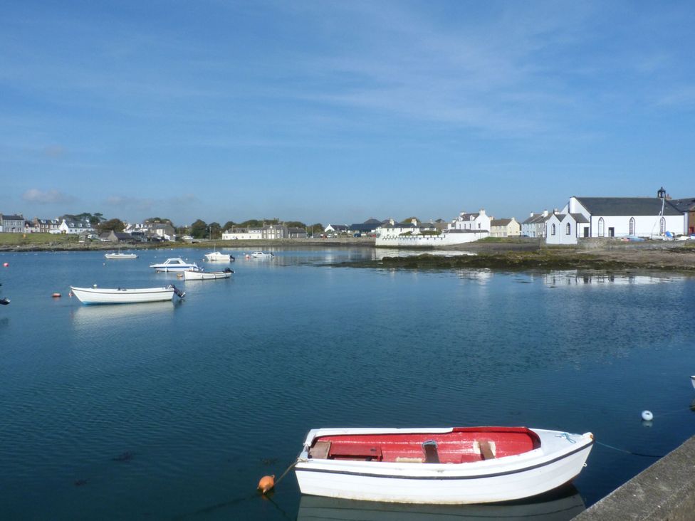 A view of boats on water with houses and sky at 15 Laigh Isle 