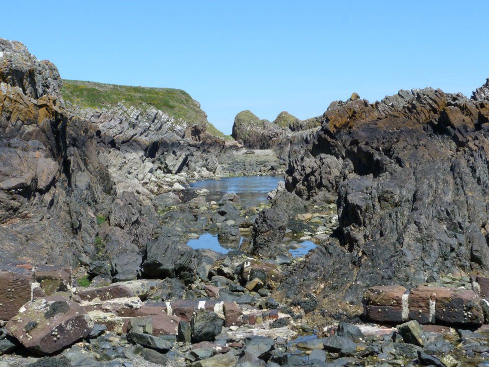A rocky shore with water at 15 Laigh Isle in 