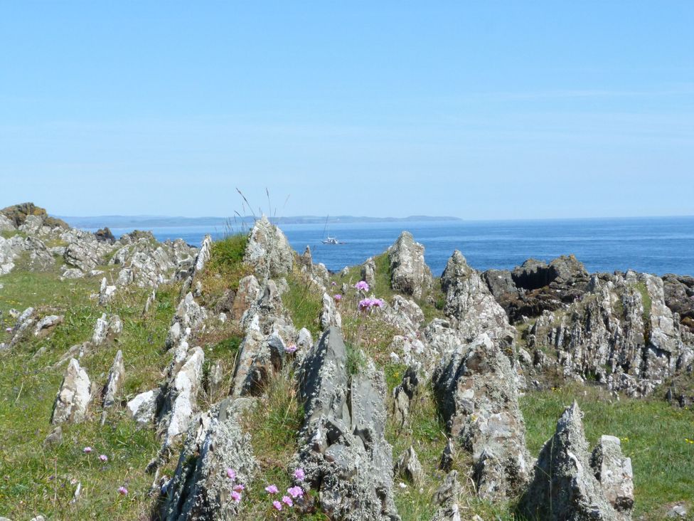 Rock formations by the sea with a boat in the distance