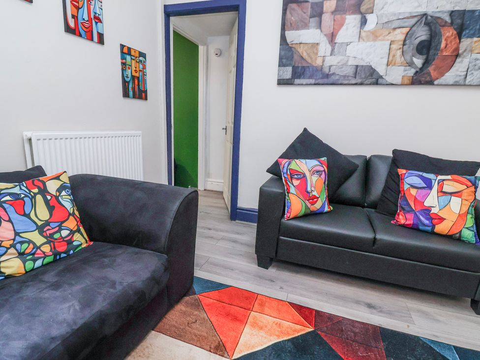 A living room with sofas and wall art at Ince Lodge in Liverpool