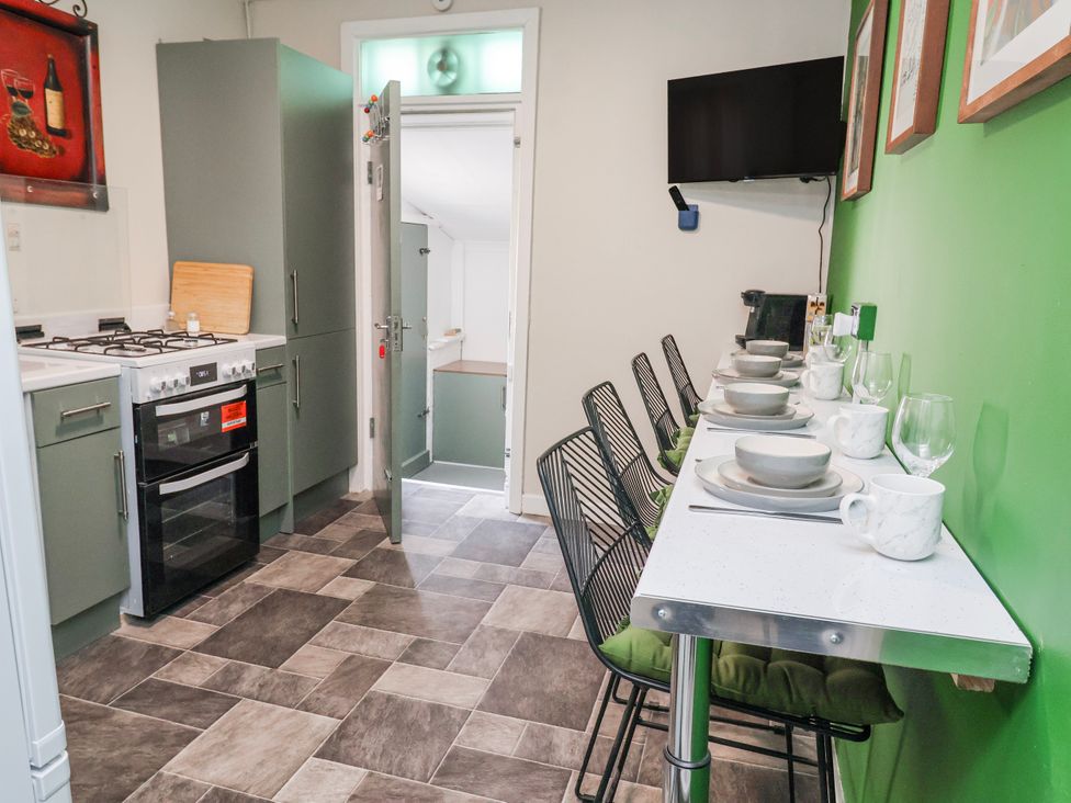 A kitchen with a stove, oven, and dining area at Ince Lodge, Liverpool