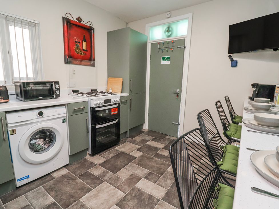 A kitchen with appliances and seating at Ince Lodge Liverpool