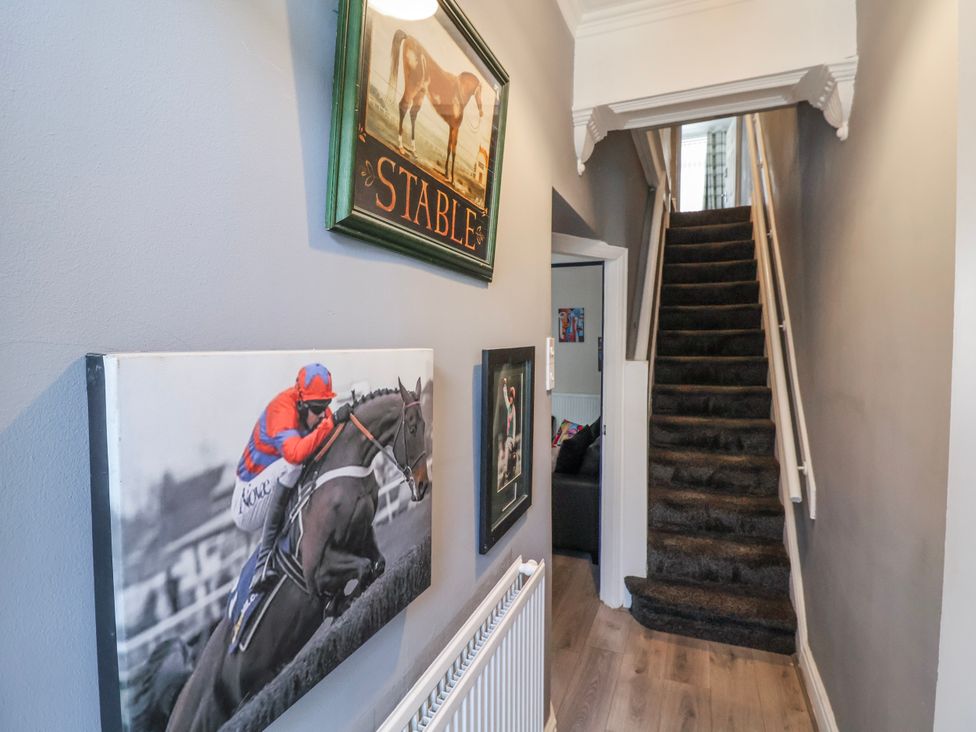 A hallway with stairs and paintings at Ince Lodge in Liverpool