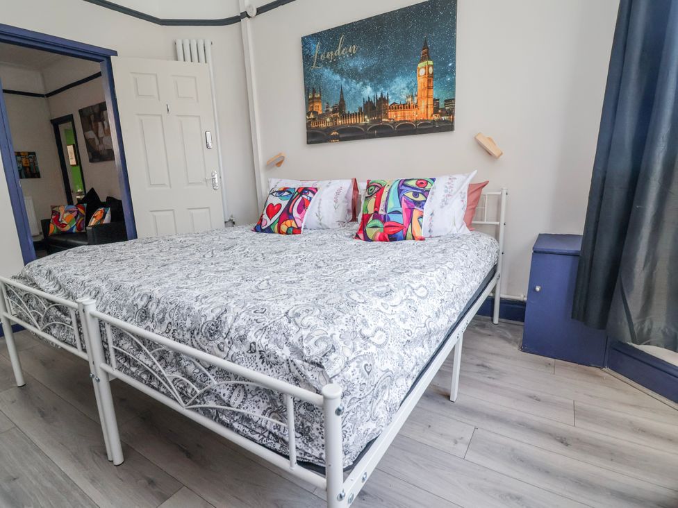 A bedroom with a bed and wall art at Ince Lodge Liverpool