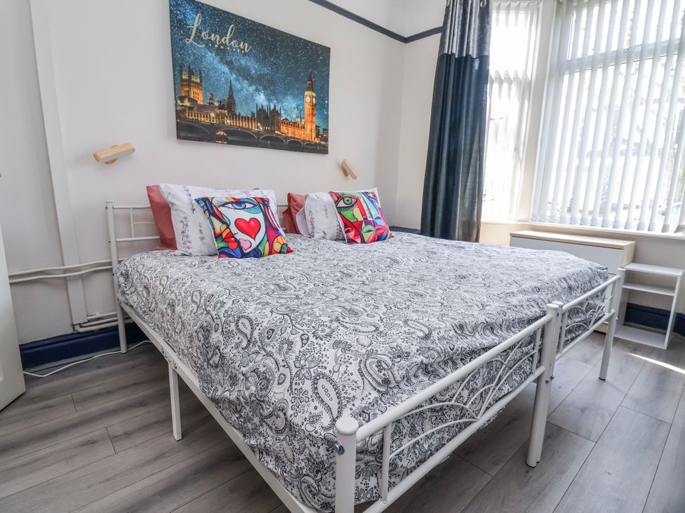 A bedroom with a double bed and wall art at Ince Lodge Liverpool