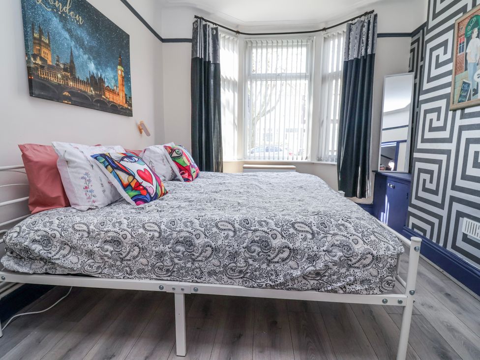 A bedroom with a bed and wall art at Ince Lodge in Liverpool