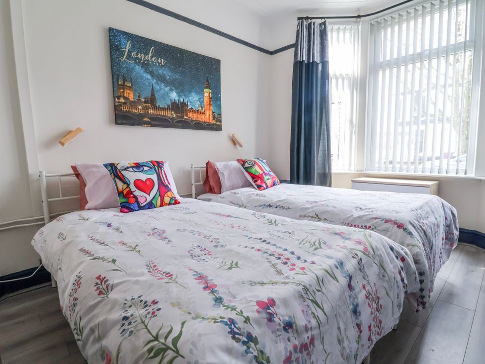 A bedroom with two beds and wall art at Ince Lodge Liverpool