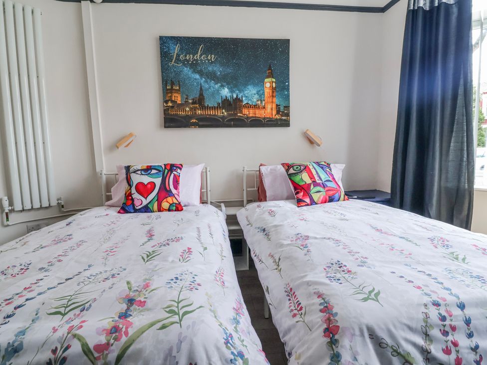 A bedroom with two beds and wall art at Ince Lodge Liverpool