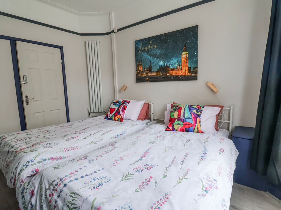 A bedroom with two beds and a wall art at Ince Lodge in Liverpool