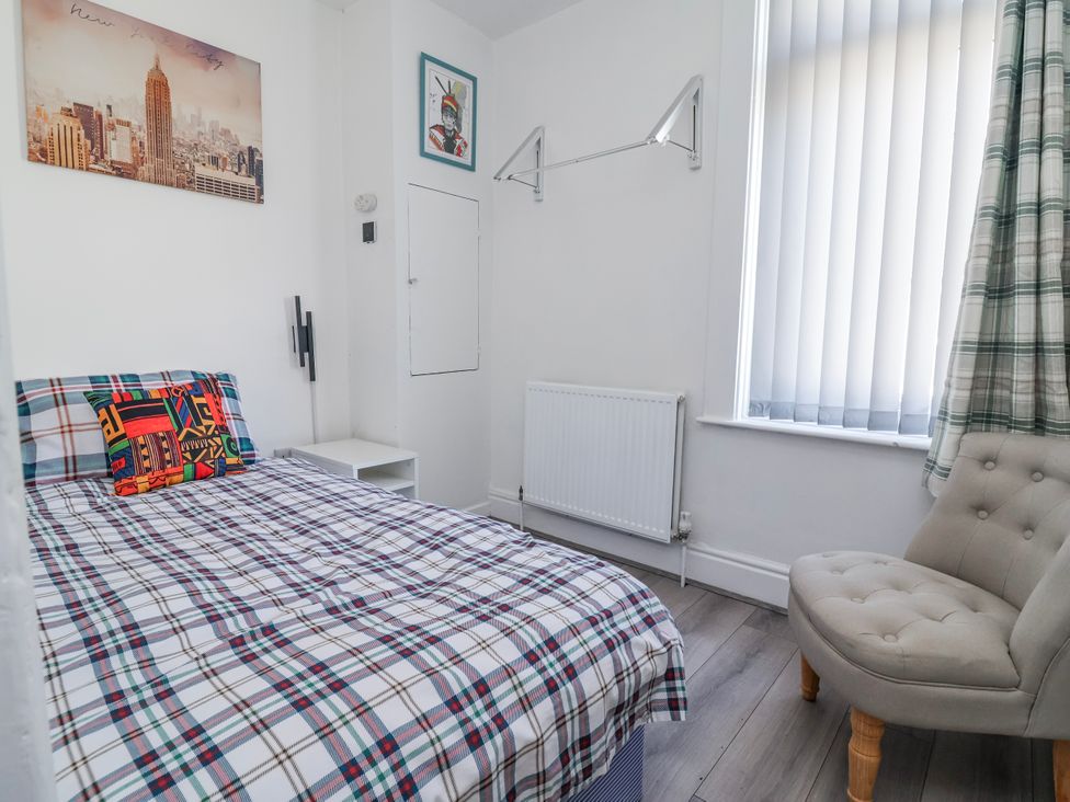 A bedroom with a bed and chair at Ince Lodge Liverpool