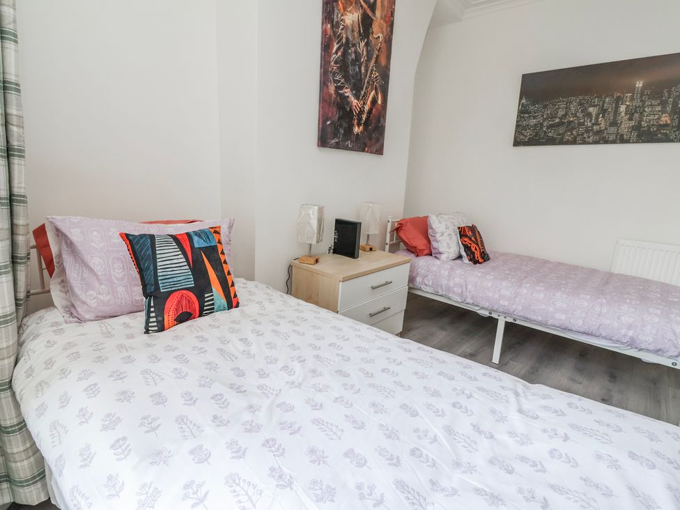 A bedroom with two beds and a nightstand at Ince Lodge Liverpool