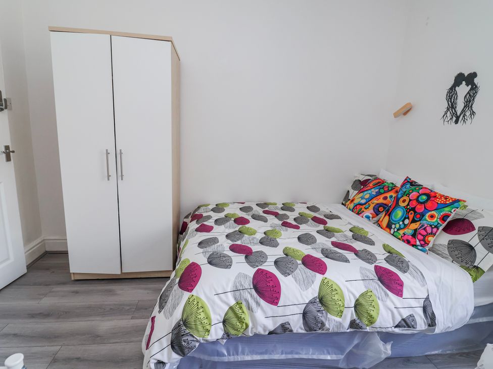 A bedroom with a bed and wardrobe at Ince Lodge in Liverpool