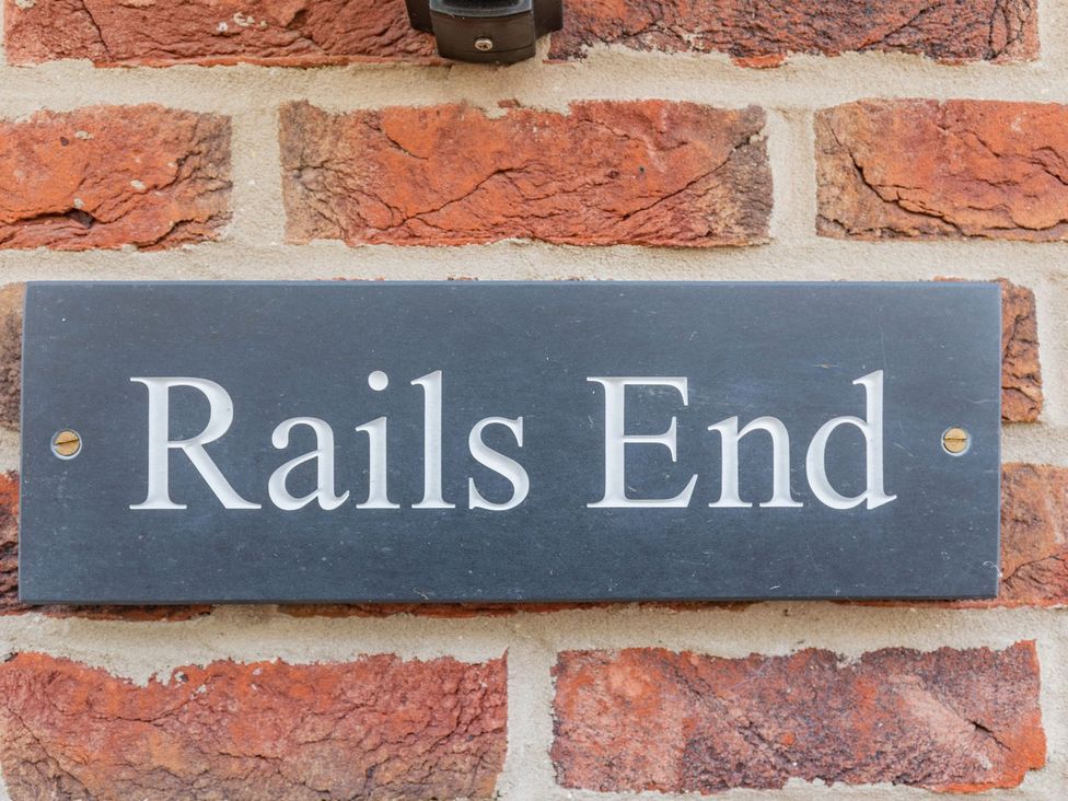 A nameplate on a brick wall at Rails End