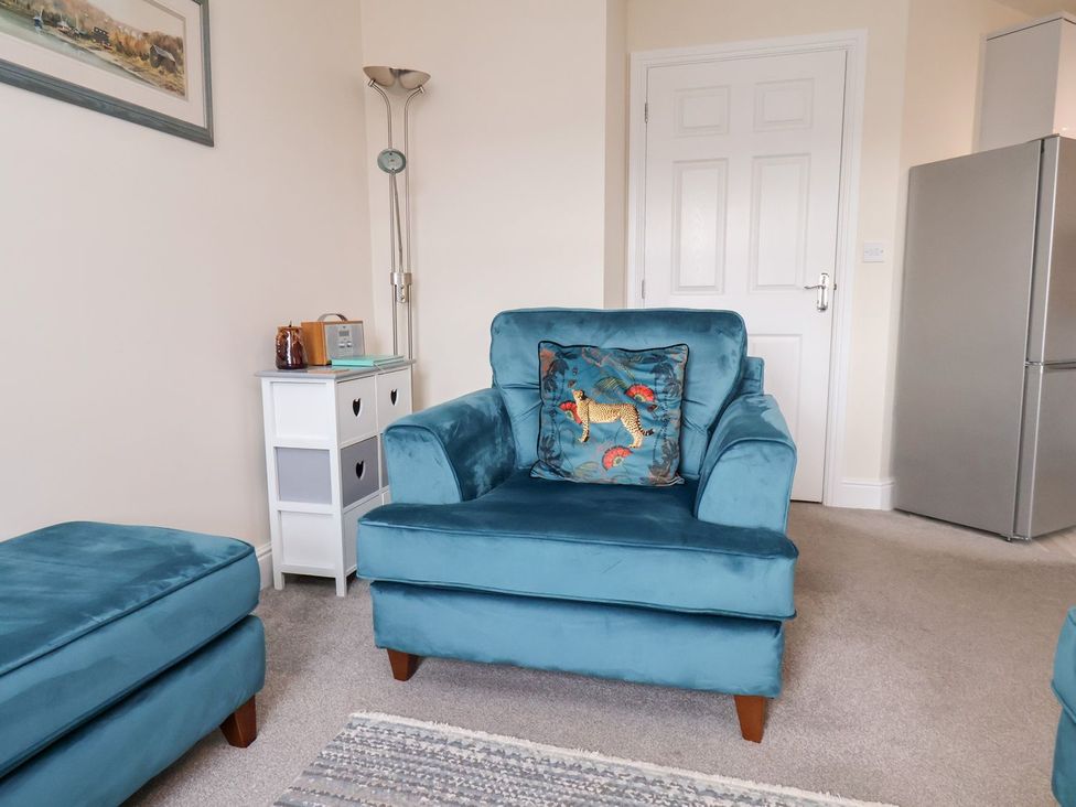 A living room with an armchair and a side table at Rails End