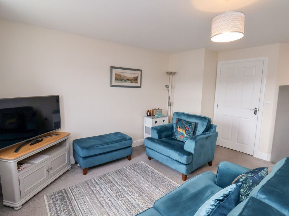 A living room with a television and seating at Rails End