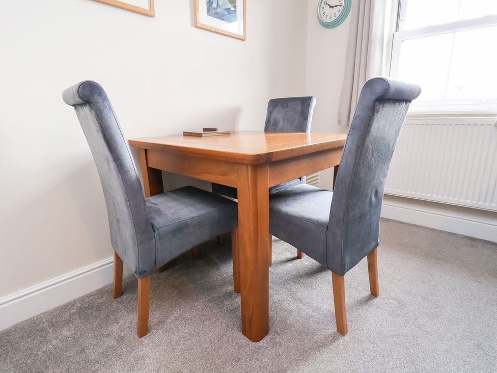 A dining table with chairs in a room at Rails End 
