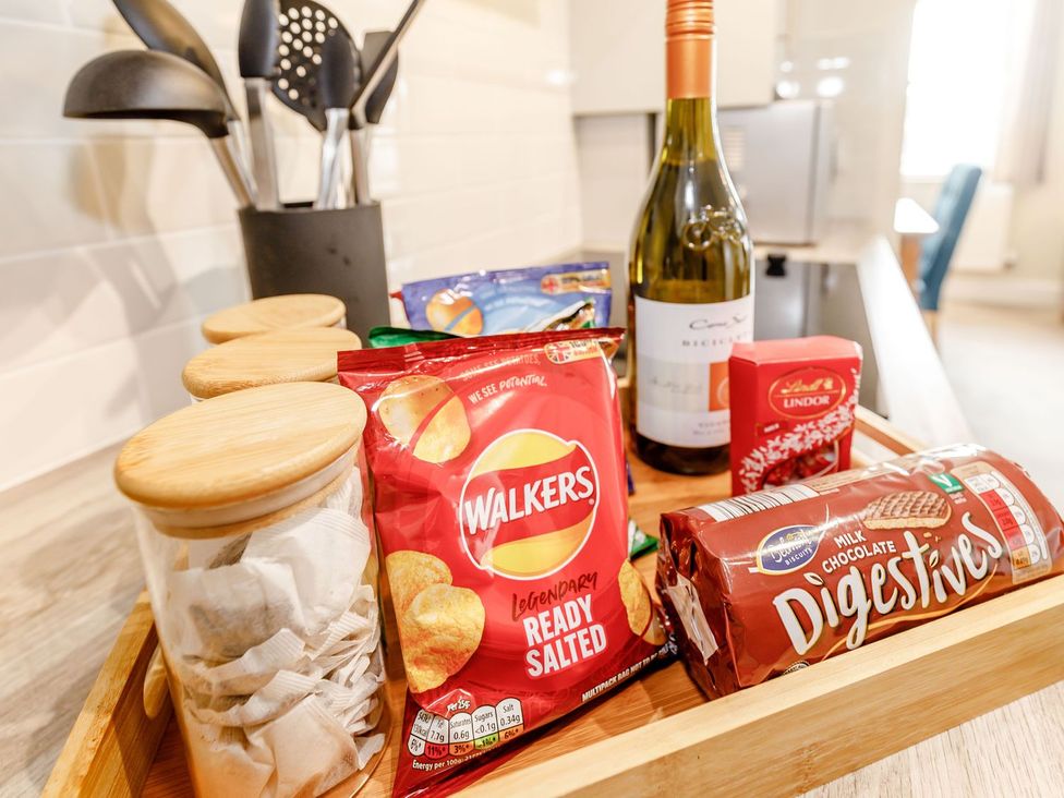 A kitchen countertop with snacks and a bottle of wine at Rails End