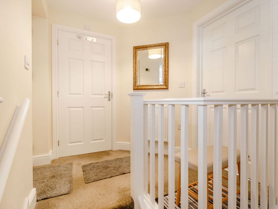 A hallway with a mirror and doors at Rails End