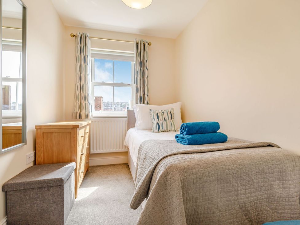 A bedroom with a single bed and dresser at Rails End