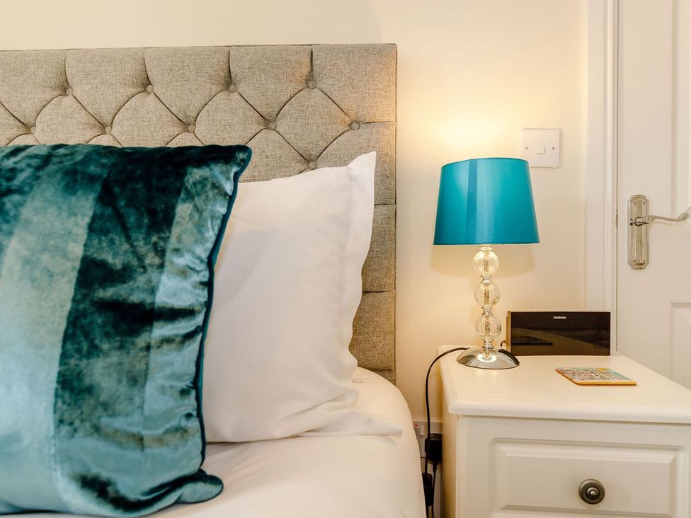 A bedroom with a headboard and nightstand at Rails End