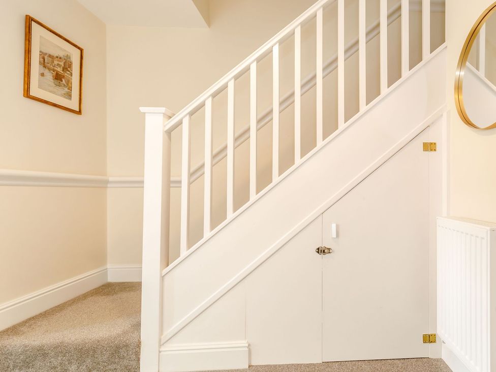 A staircase with a picture frame and a door under the stairs at Rails End