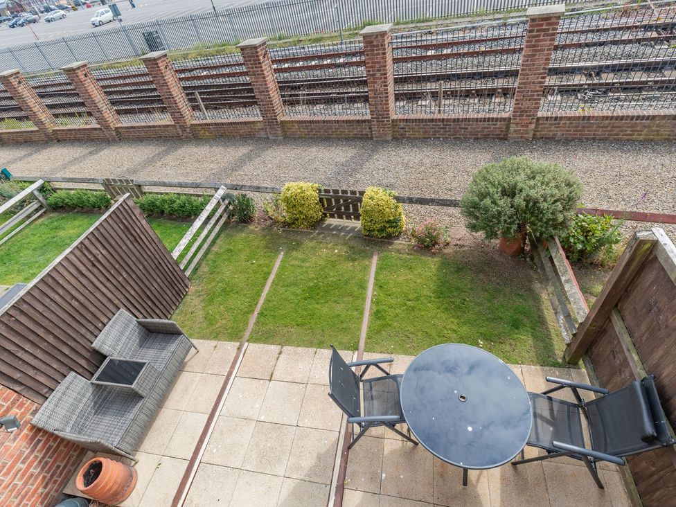 A patio with a table and chairs overlooking railway tracks at Rails End