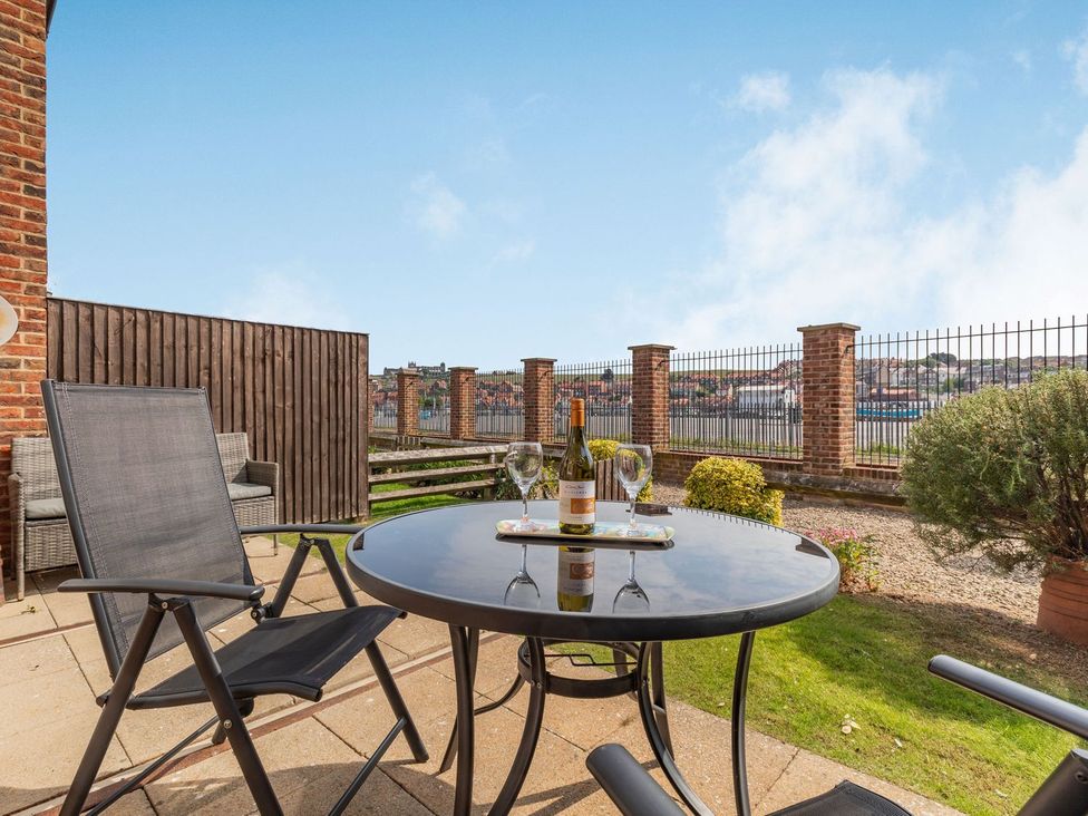 An outdoor patio with a table and chairs at Rails End 