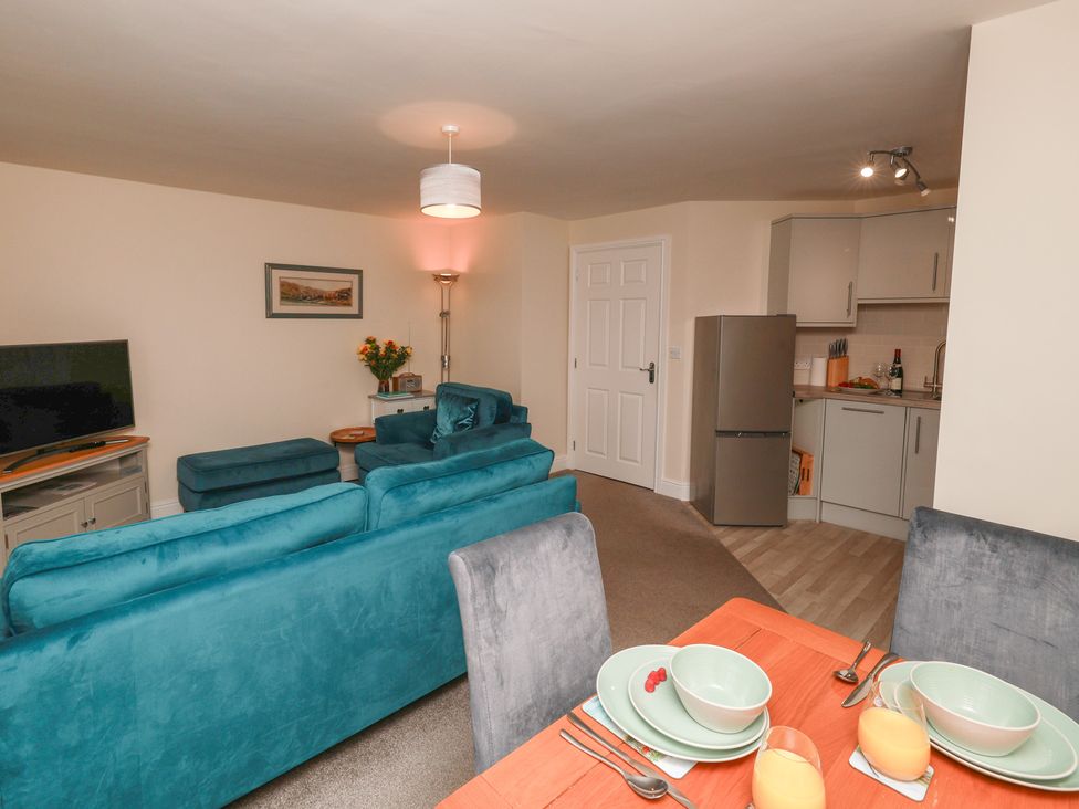 A living room with a television and dining area at Rails End in Whitby